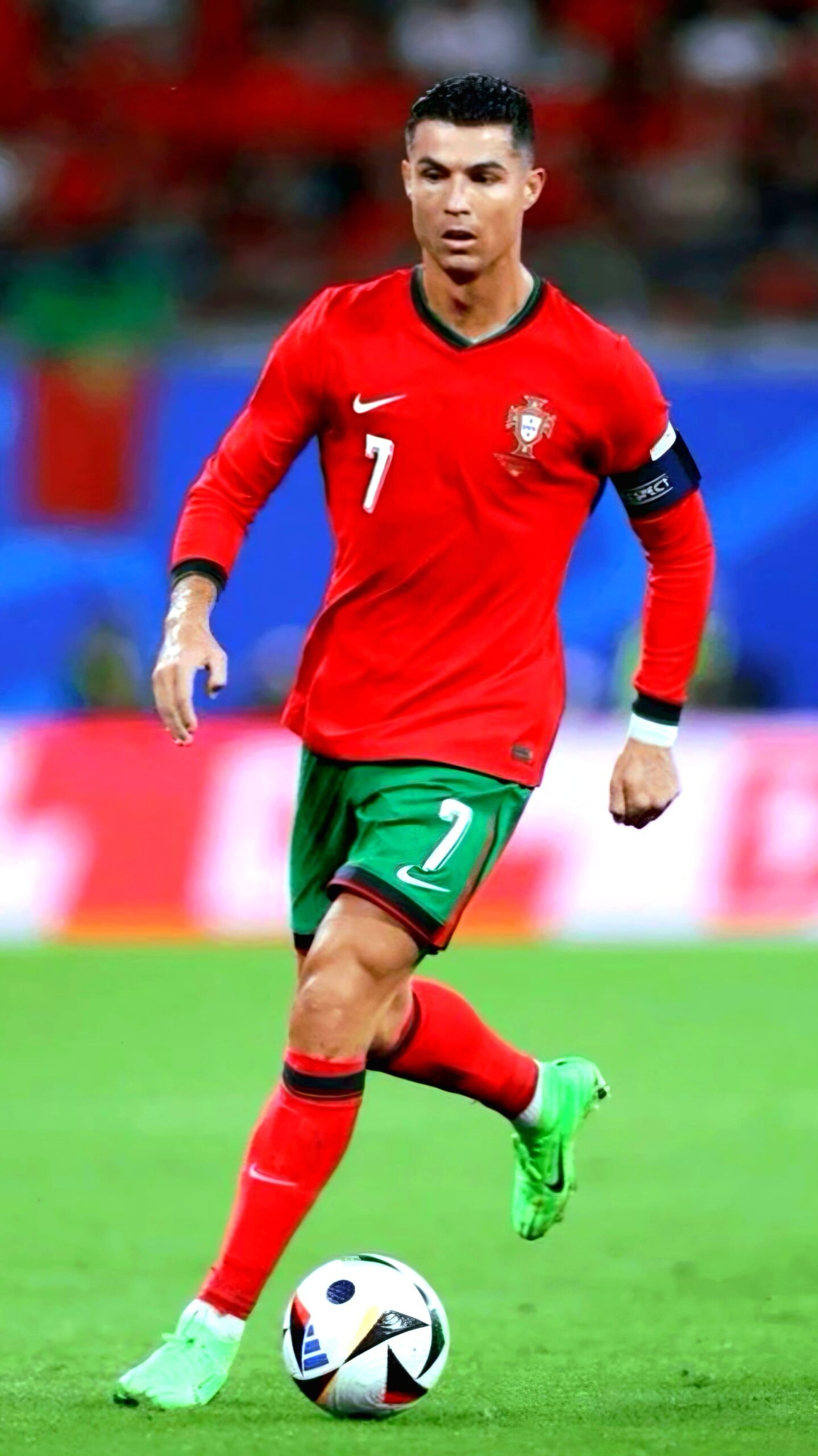 A male soccer player in a red Portugal jersey with the number 7 and a captain's armband is running on the field during a match, about to kick a soccer ball, streamed live via Latino IPTV for fans everywhere.